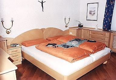 Doppelbett mit Nachtkästchen
            und Anrichten